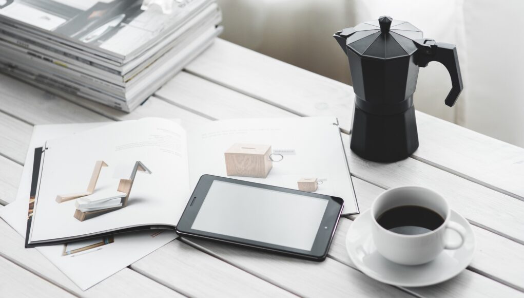 Pracovní stůl s kávou , čtečkou a časopisem